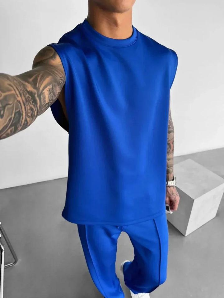 Set lounge uomo estivo, con top senza maniche e pantaloni sartoriali, per un look fresco e disinvolto.