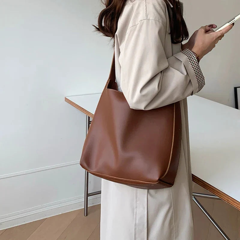 Borsa da donna similpelle versatile, disponibile in nero e marrone, con opzione tracolla o a spalla.