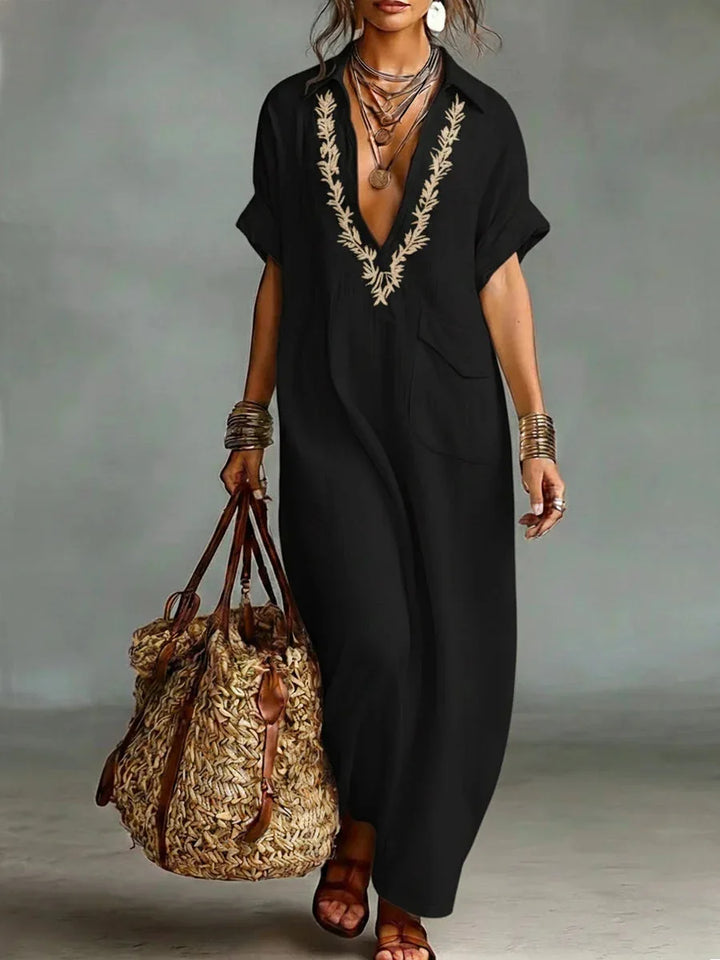 Donna rilassata che passeggia con abito lungo boho estivo, ricamato e con tasche, perfetto per l'estate.