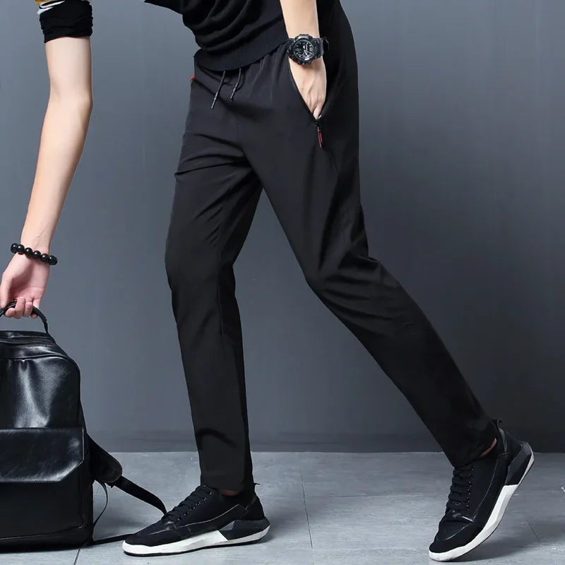 Pantaloni uomo casual slim con vita elastica e tasche zip, ideali per comfort quotidiano e look moderno.