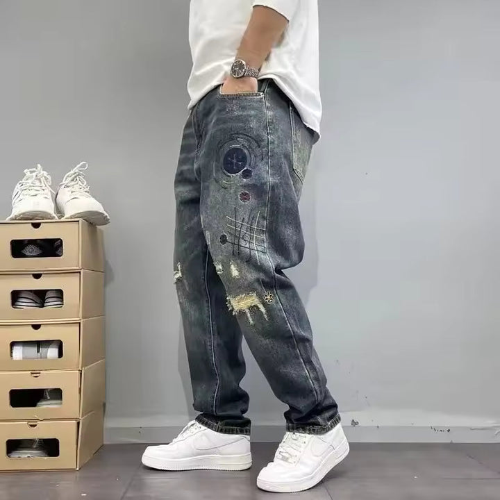 Jeans uomo blu grigio dal fit comodo e relaxed. Dettagli vissuti e strappi, perfetti per un outfit casual e alla moda.