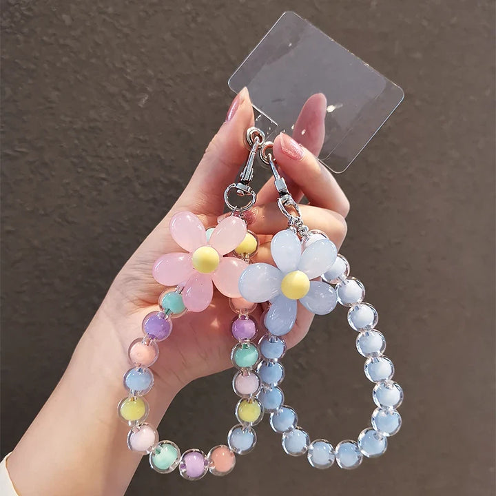 Accessorio telefono donna, laccetto con perline macaron pastello e fiore, per smartphone elegante.
