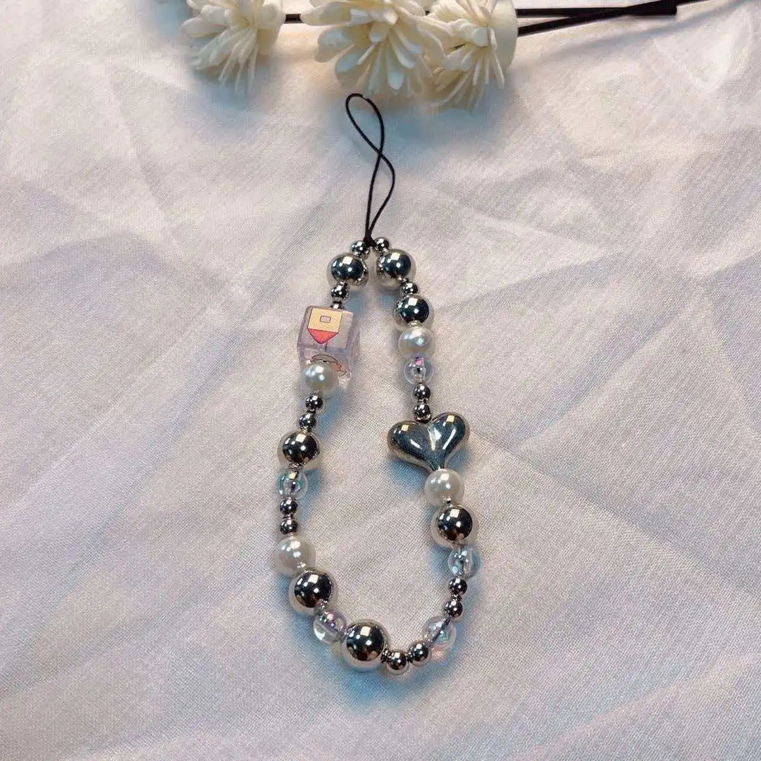 Accessorio moda donna, laccetto telefono con perline macaron e fiore, per un tocco di originalità unica.