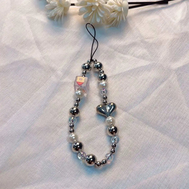 Accessorio moda donna, laccetto telefono con perline macaron e fiore, per un tocco di originalità unica.