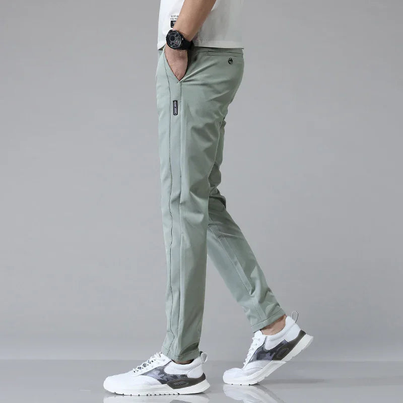 Pantaloni uomo antipiega grigi, affusolati, ideali per comfort e stile in ufficio o viaggio.