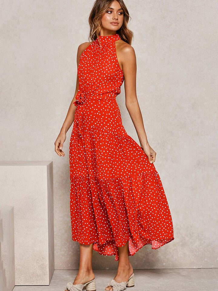 Modella indossa abito midi svasato a pois, ideale per passeggiate estive o eventi. Eleganza e comfort.