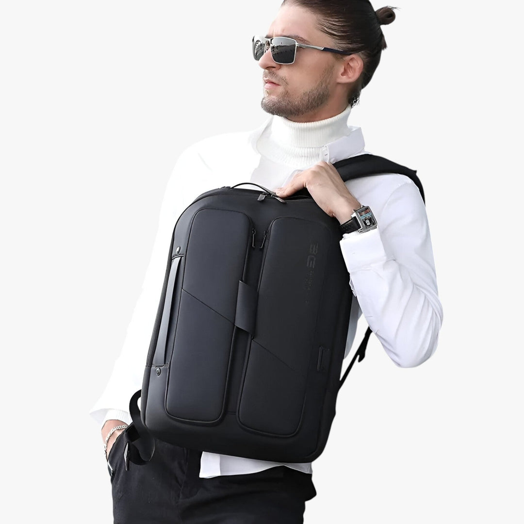 Uomo con zaino porta laptop nero elegante e funzionale con USB, ideale per spostamenti di lavoro in città.