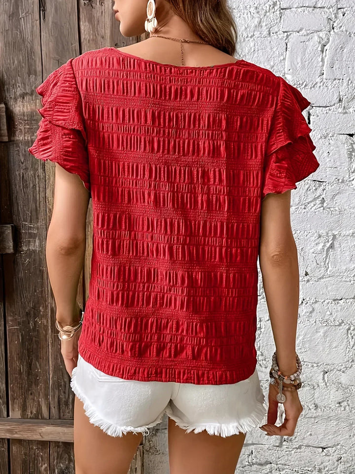 Camicetta estiva da donna con volant, in tessuto leggero per comfort quotidiano e stile alla moda.