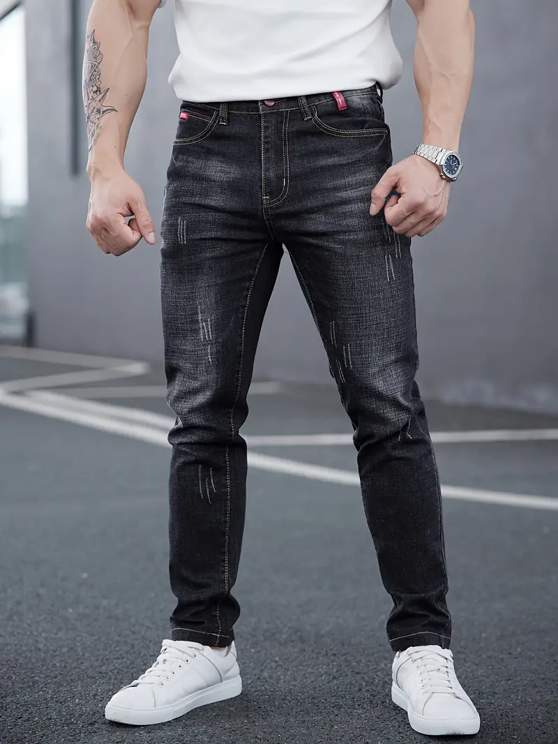 Jeans uomo tapered in denim, vita media, chiusura a bottoni. Stile casual con vestibilità slim affusolata.