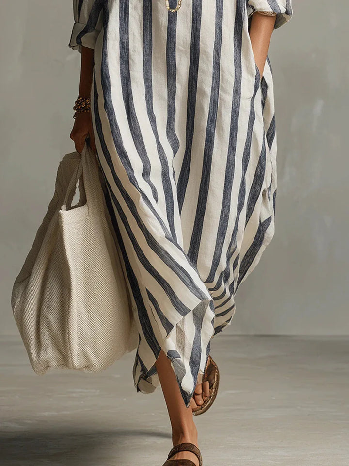 Abito chemisier donna lungo a righe, vista laterale che evidenzia la fluidità, per un look estivo chic.