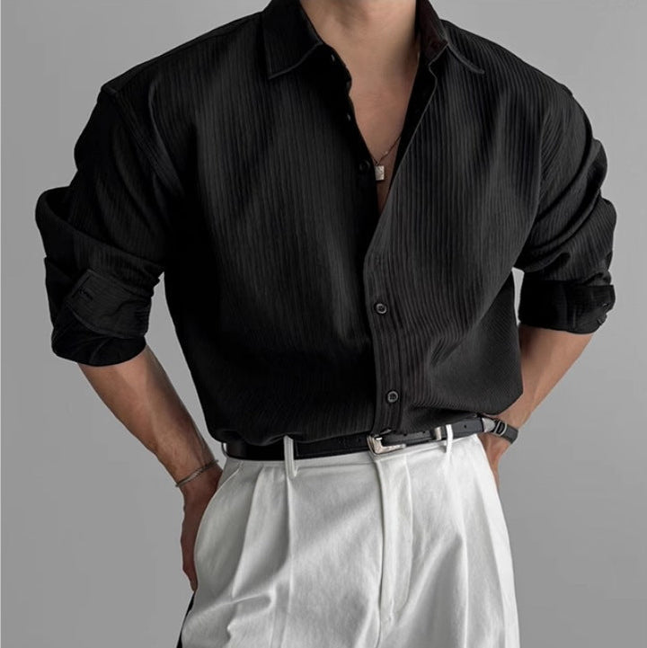 Camicia nera uomo minimalista a maniche lunghe con delicate pieghe, per un look moderno.