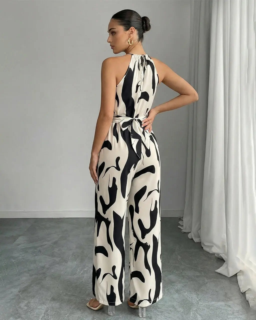 Tuta fluida donna con collo halter e vivace stampa astratta. Outfit elegante per eventi.