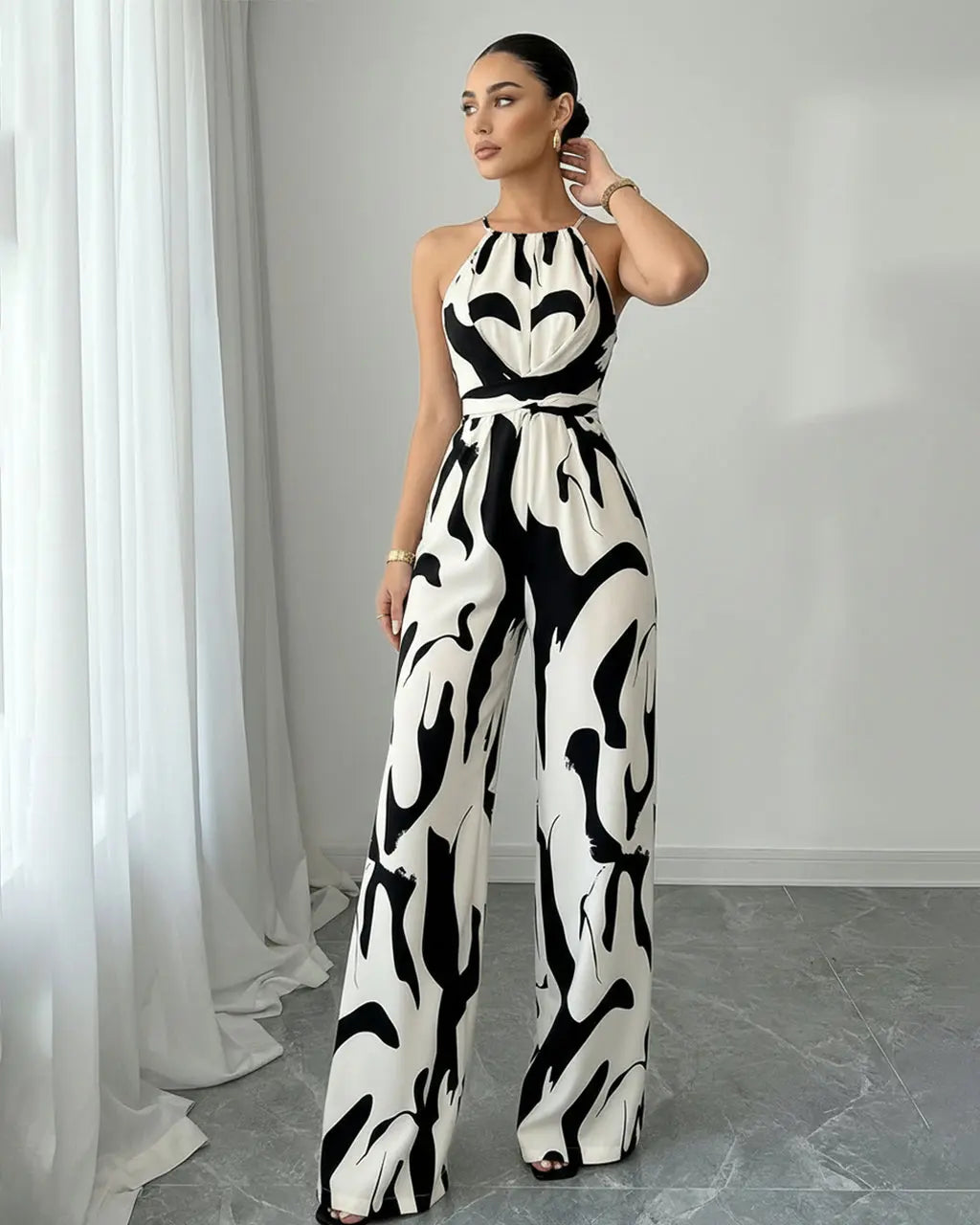 Tuta da donna sofisticata con stampa astratta, scollo halter. Design elegante e fluente, gamba ampia.