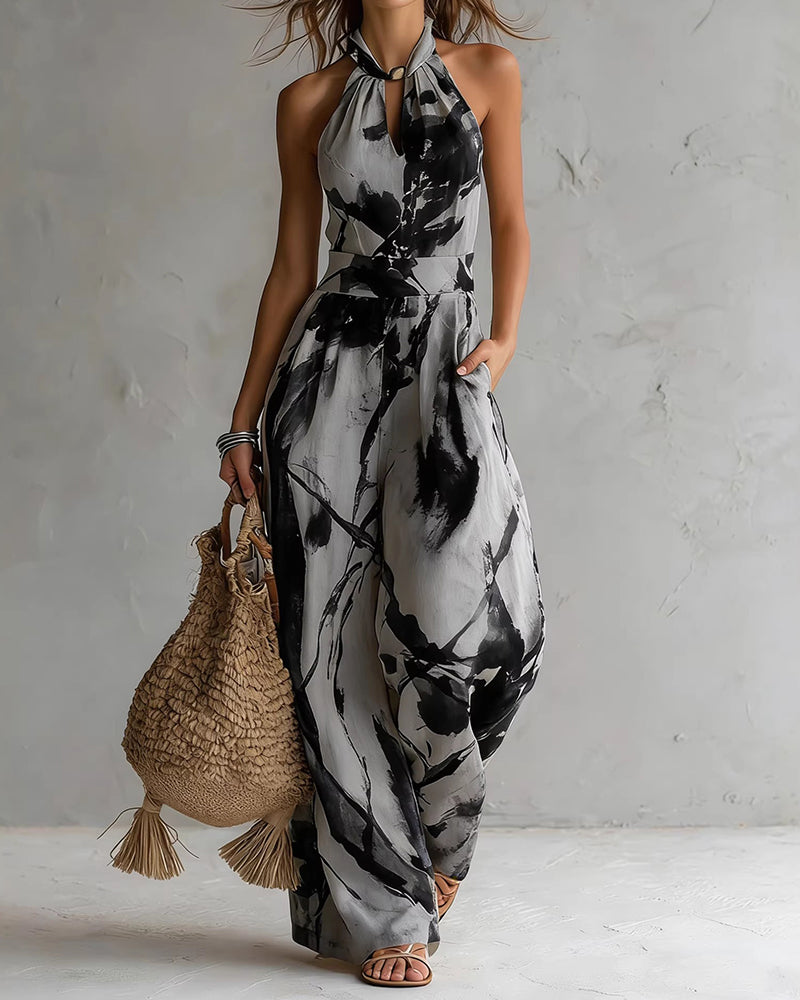 Tuta donna versatile con stampa acquerello, scollo halter e pantaloni larghi. Perfetta per outfit casual o eleganti.