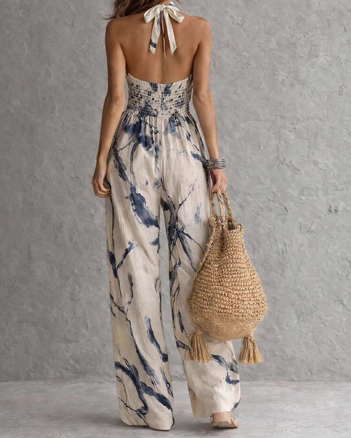 Abito intero donna estivo con stampa acquerello, scollo halter e silhouette fluida. Stile chic e leggero.