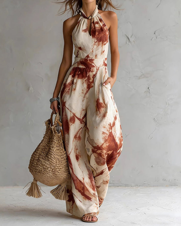 Jumpsuit donna elegante con scollo halter, stampa acquerello vivace e pantaloni ampi per un comfort estivo.