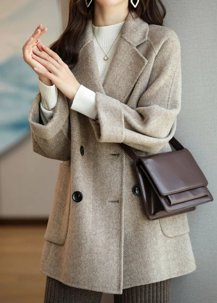 Cappotto autunnale donna doppiopetto, vestibilità classica, con ampio rever e bottoni a contrasto.