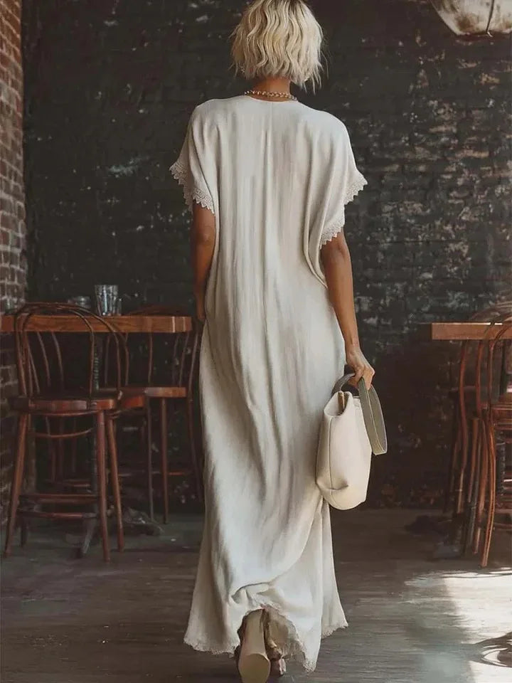 Elegante abito lungo da donna con scollo a V e delicati inserti in pizzo, stile fluido.