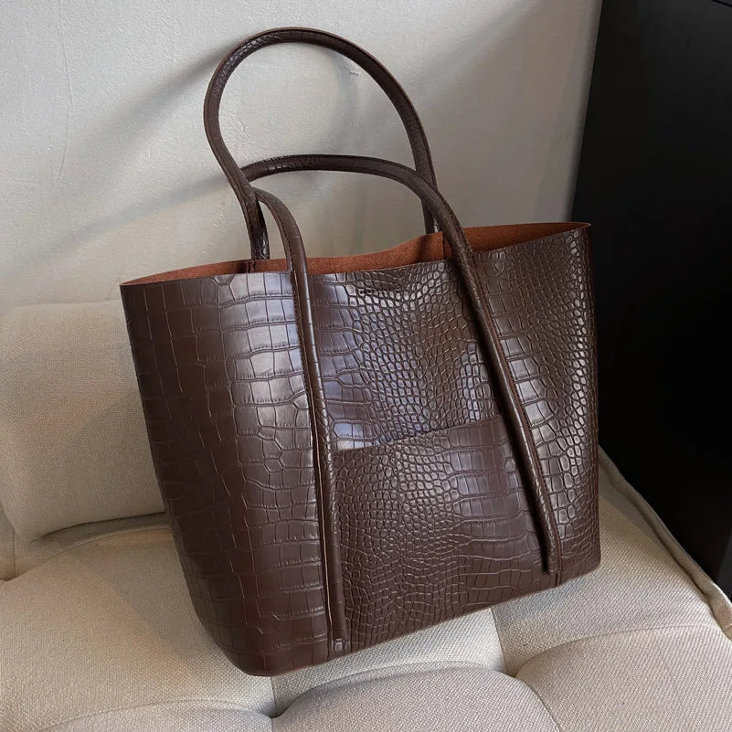 Borsa tracolla donna in pelle coccodrillo, design elegante con chiusura frontale, accessorio moda versatile.