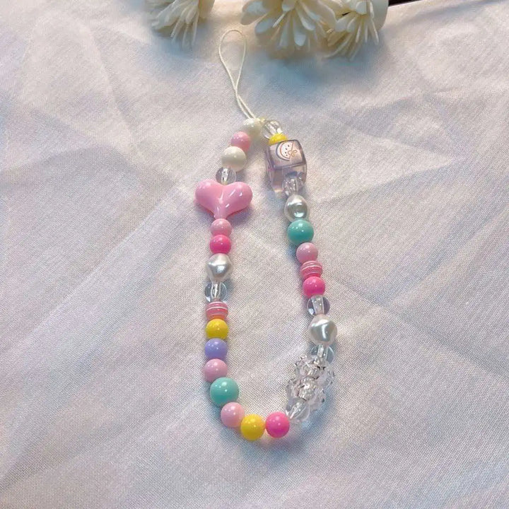 Laccetto smartphone donna, perline macaron e fiore, un accessorio che arricchisce il tuo stile con un tocco di colore.