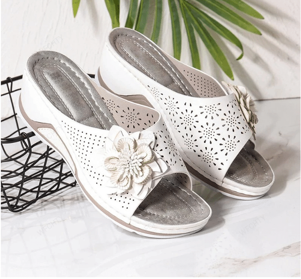 Sandali estivi donna slip-on con zeppa, supporto plantare per massimo comfort. Design traforato, tocco floreale.