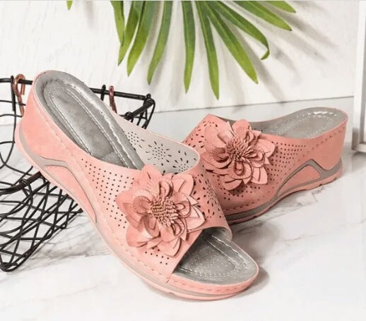 Sandali donna con zeppa e applicazione floreale. Modello slip-on, plantare comfort, perfetti per l'estate.