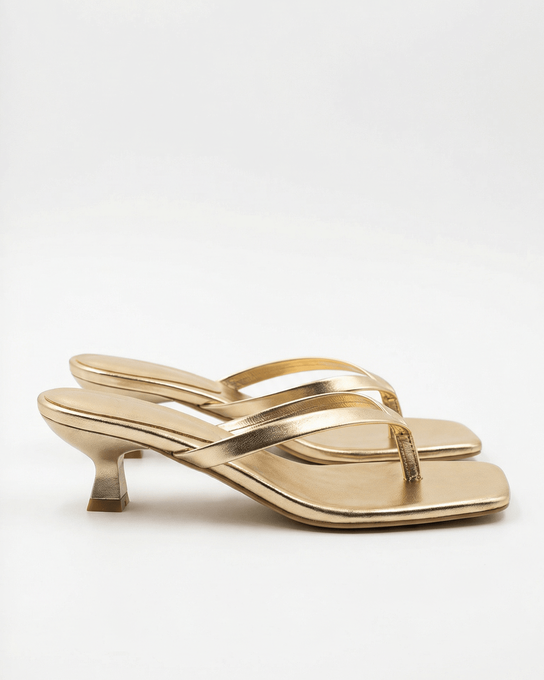 Sandali donna minimalisti con tacco kitten heel, punta quadrata e fascette incrociate.