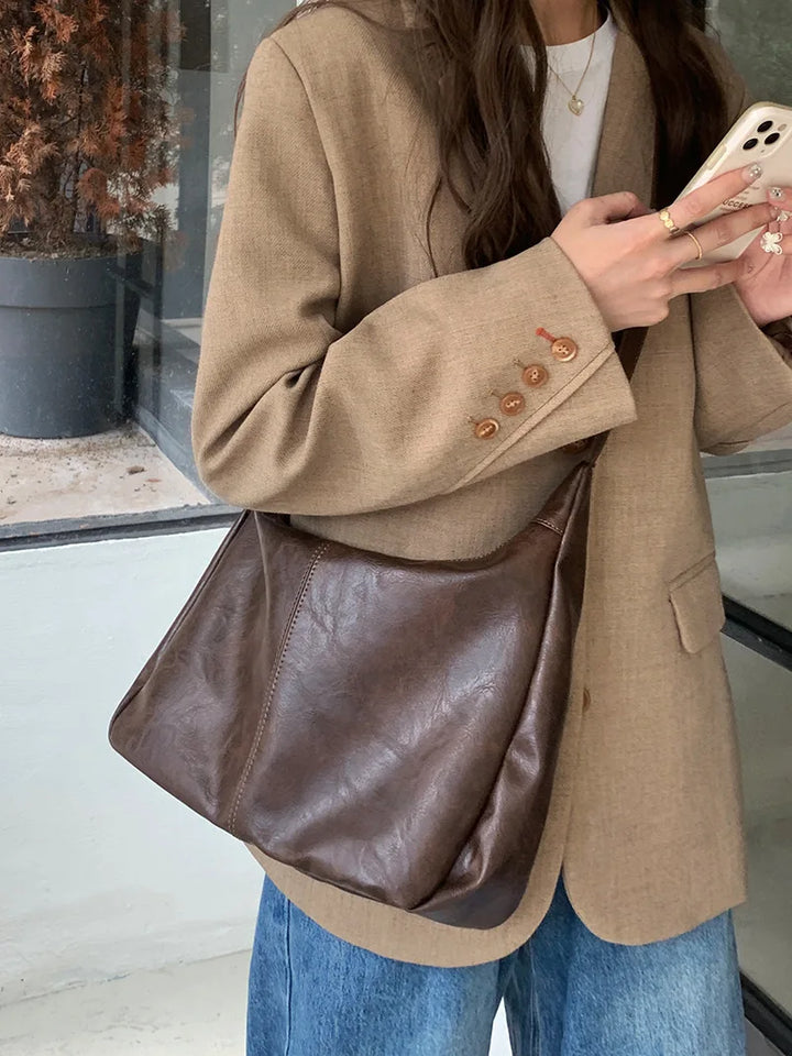 Borsa a tracolla da donna elegante in ecopelle marrone, perfetta per un look sofisticato e quotidiano.