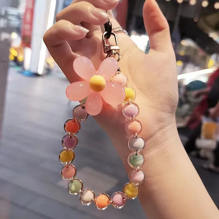Accessorio moda donna: laccetto telefono con perline macaron e fiore, ideale per il polso, comodo.