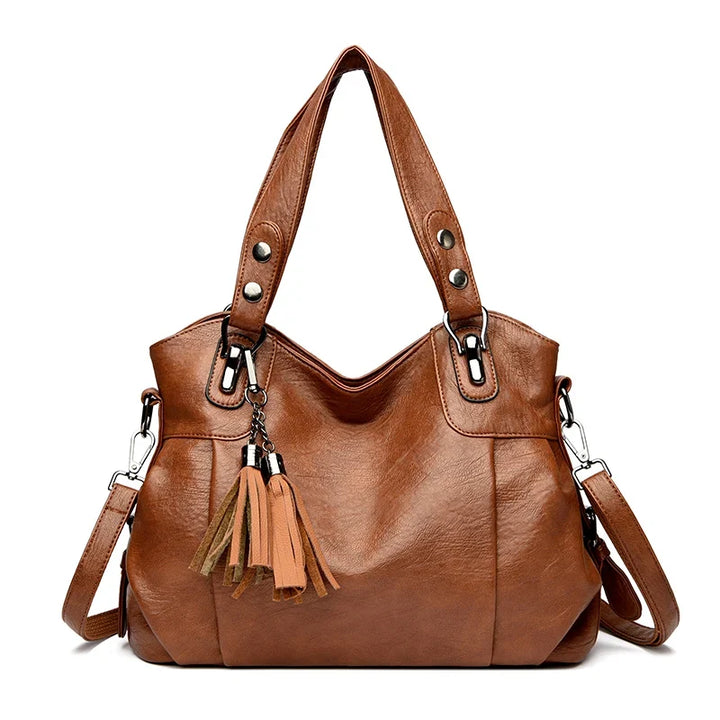 Elegante borsa nera da donna con manici e tracolla removibile, ideale per outfit casual e formali.