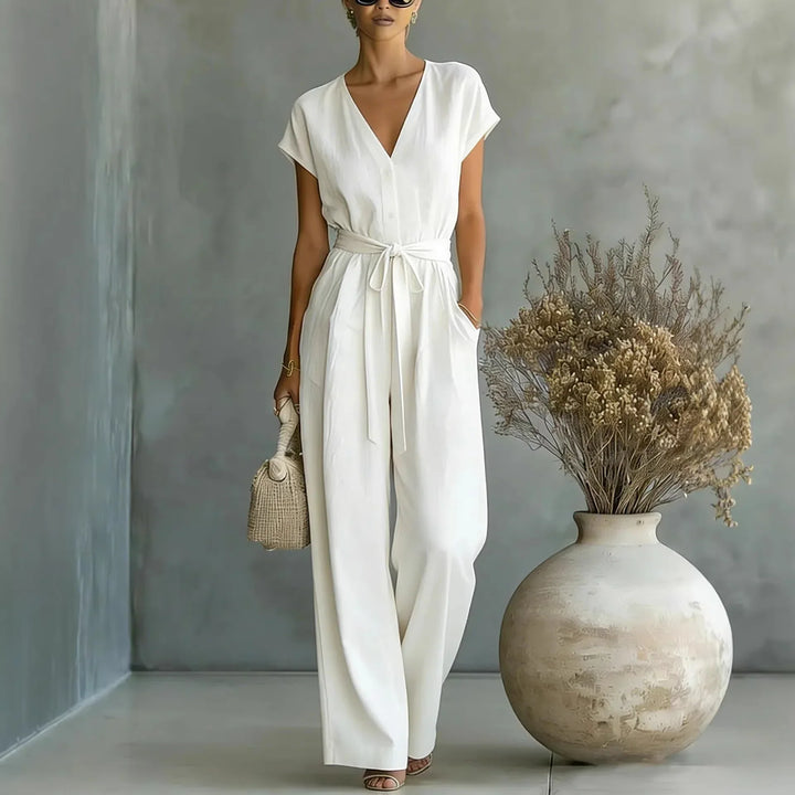 Tuta donna con pantaloni larghi e scollo a V. La cintura esalta la figura. Capo elegante e comodo per ogni occasione.