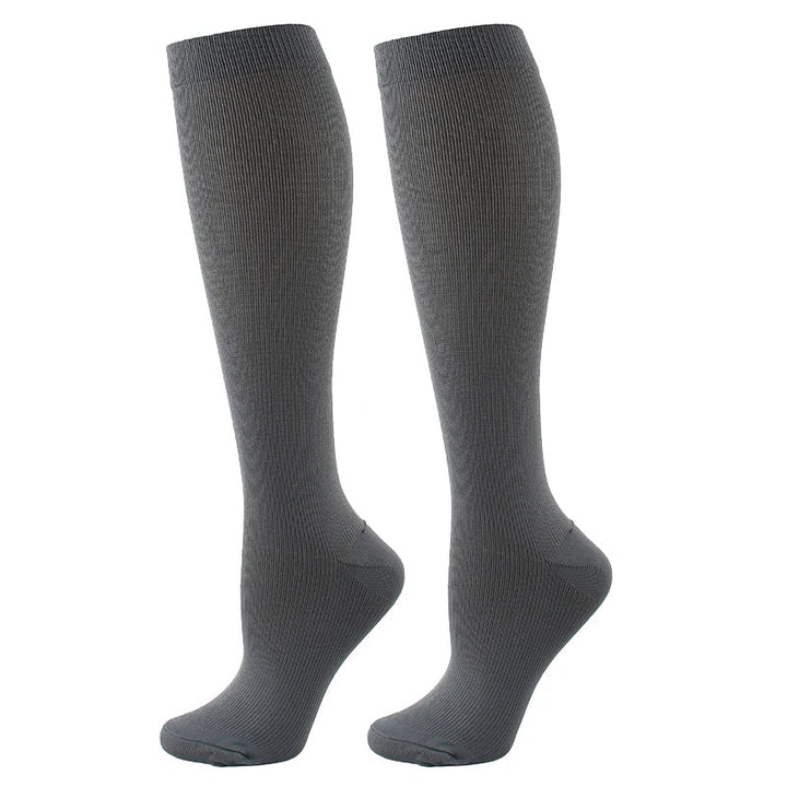 Calze compressive unisex che aiutano a prevenire crampi e dolori, perfette per sport e viaggi.