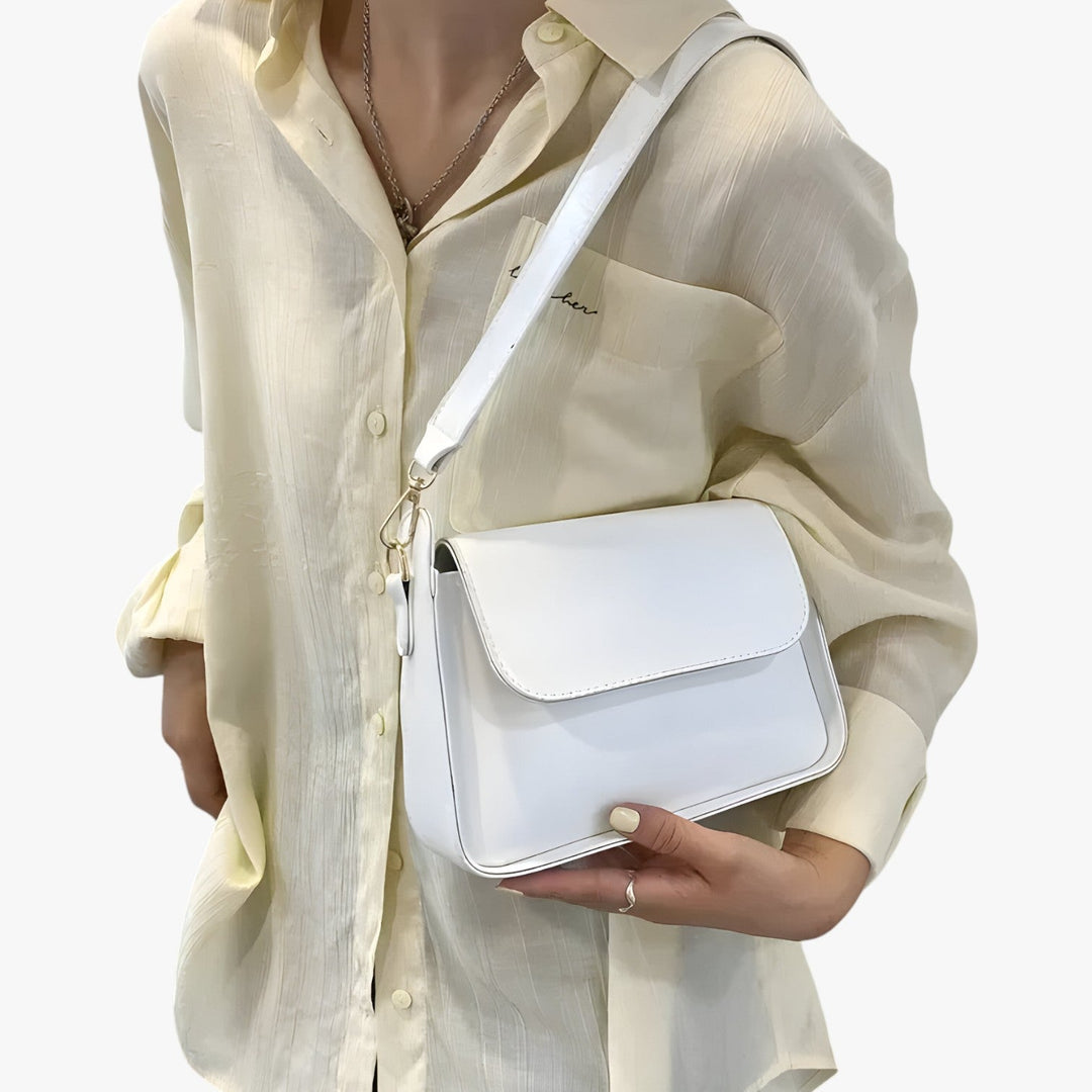 Donna con borsa a tracolla compatta, accessorio moda versatile per un outfit quotidiano e chic.
