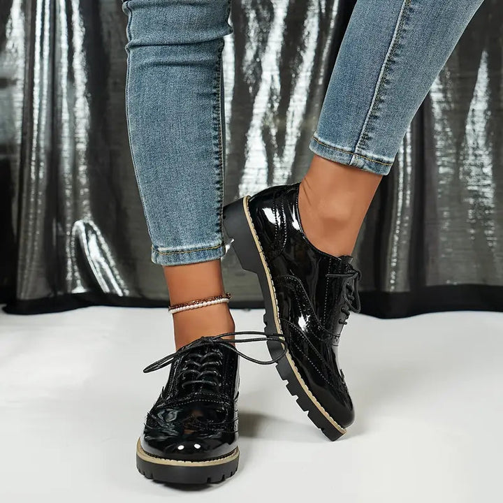 Scarpe eleganti Oxford donna nere, con dettagli brogue e suola spessa. Un mix di comfort e stile per la moda donna.