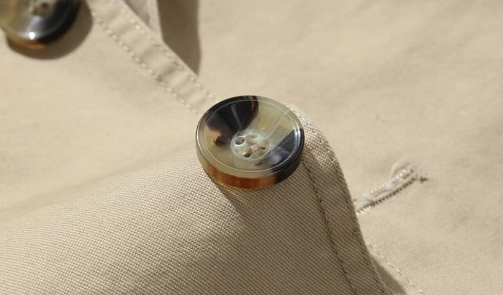 Dettaglio colletto trench uomo doppiopetto. Soprabito maschile elegante per un abbigliamento esterno raffinato.