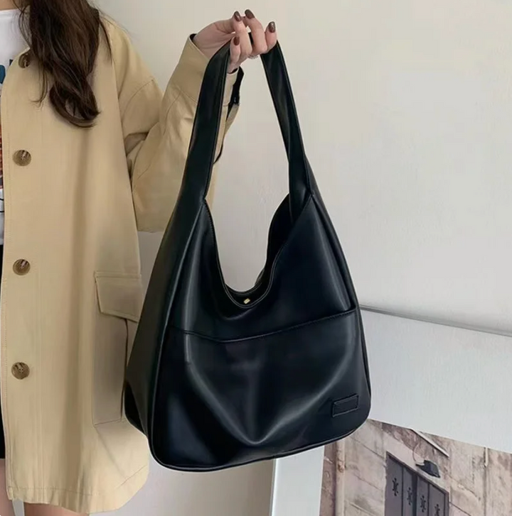 Borsa donna in similpelle nera con tracolla regolabile, design moderno e grande capacità. Accessorio versatile.