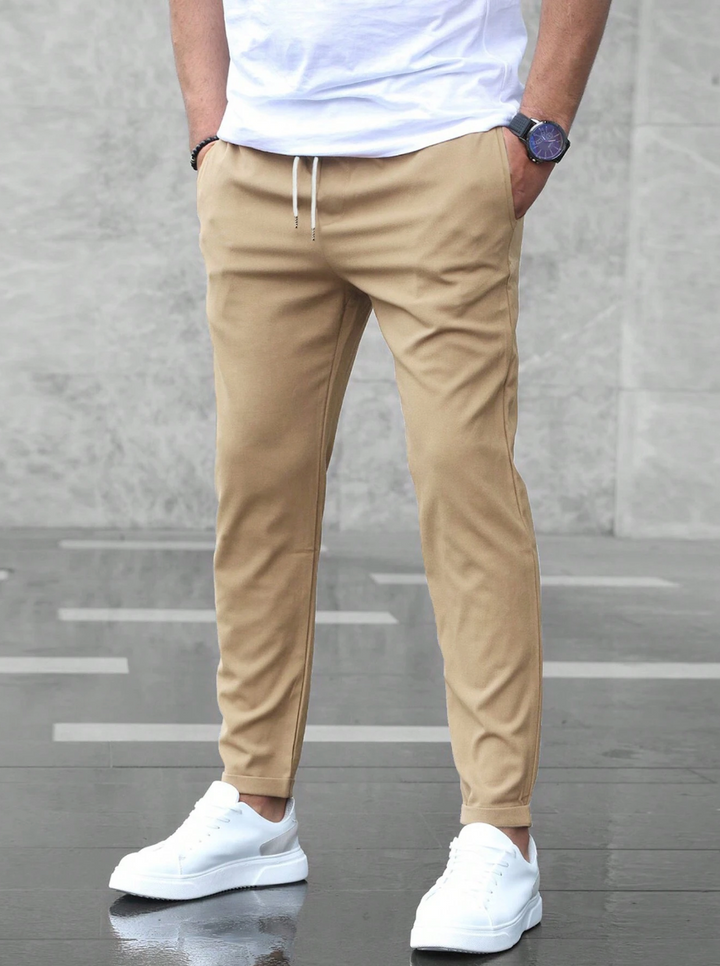 Pantaloni uomo slim fit elasticizzati verdi militari con cintura, ideali per look casual ed eleganti.