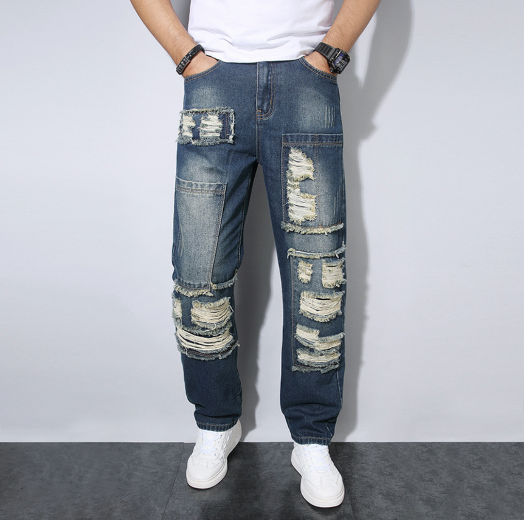 Jeans uomo loose fit strappati, tendenza streetwear. Pantaloni dritti denim per stile casual maschile.