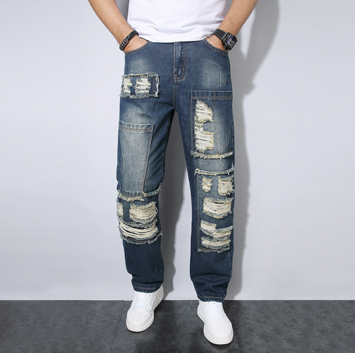 Jeans uomo loose fit strappati, tendenza streetwear. Pantaloni dritti denim per stile casual maschile.