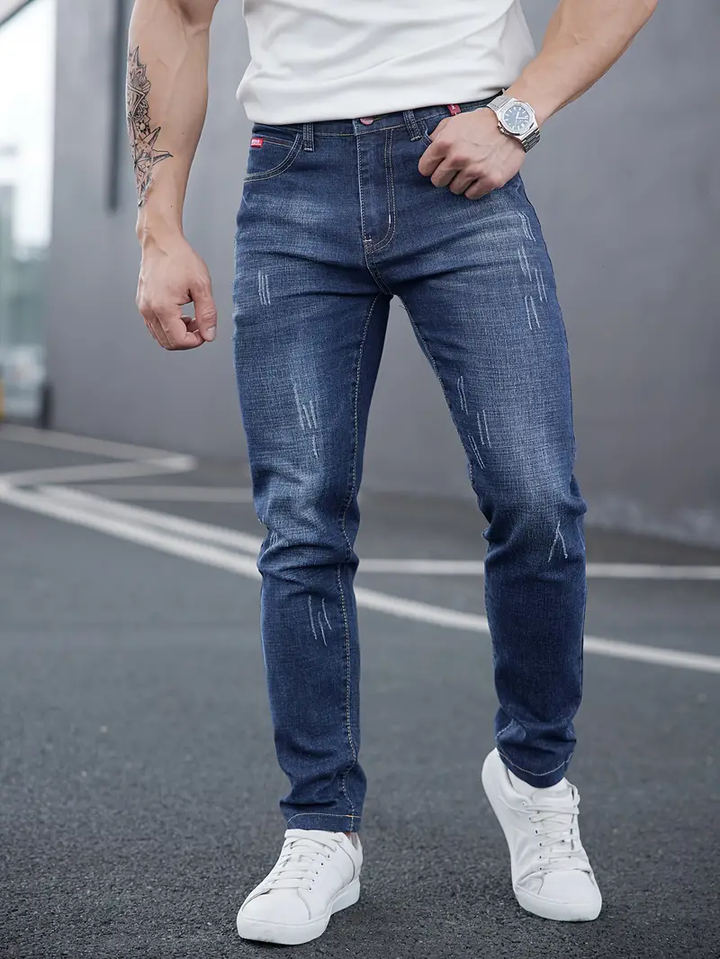 Jeans tapered uomo in denim, vita media e chiusura a bottoni. Ideali per look casual affusolato.