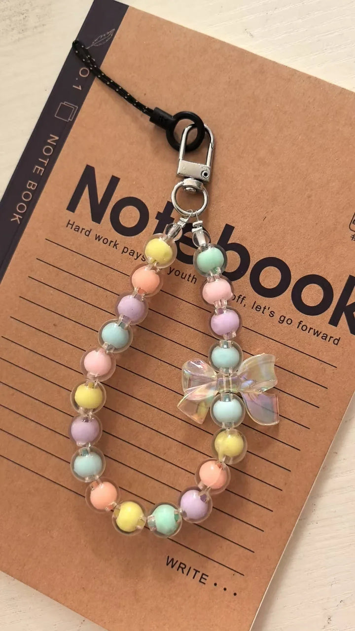 Cinturino telefono donna con perline macaron e fiore, un accessorio funzionale e bello per device.