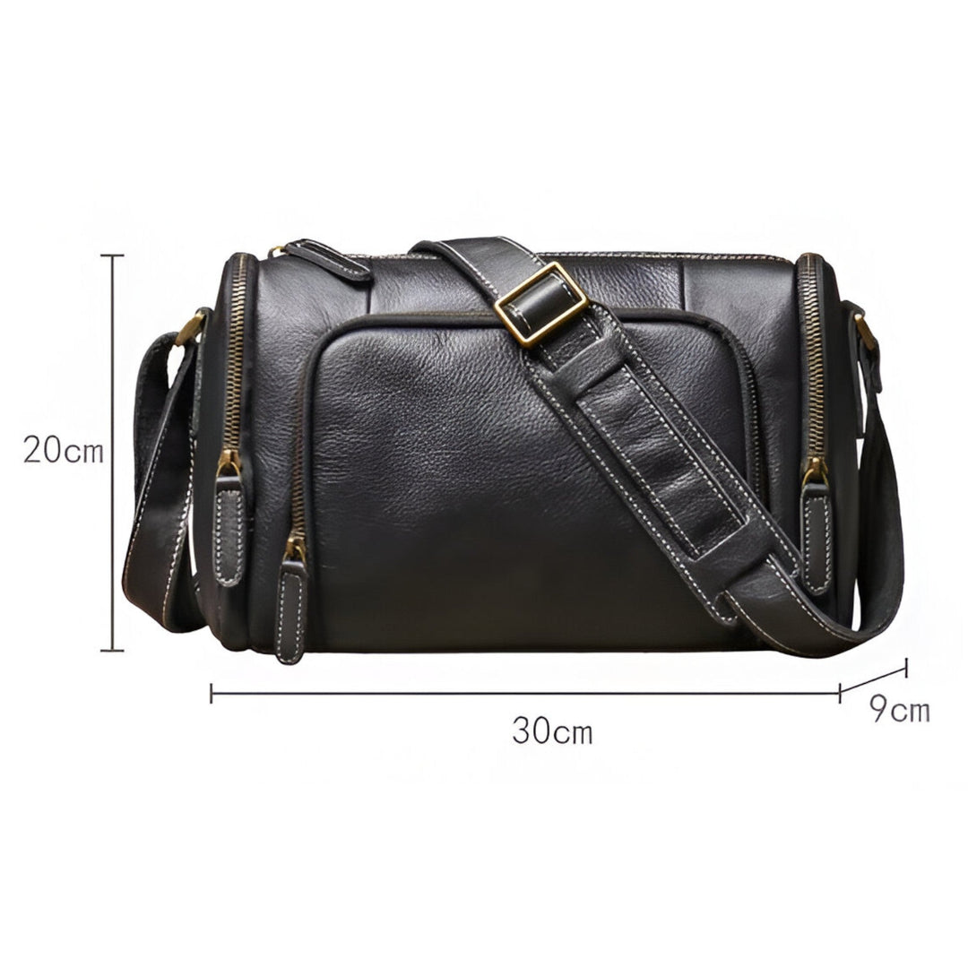 Dettaglio chiusura e cerniere robuste della borsa messenger unisex nera, sinonimo di resistenza.