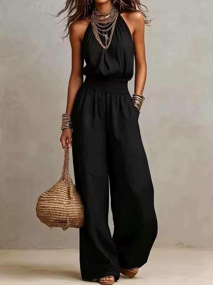 Tuta femminile in poliestere con scollo halter e pantaloni larghi. Comoda e versatile per ogni occasione.