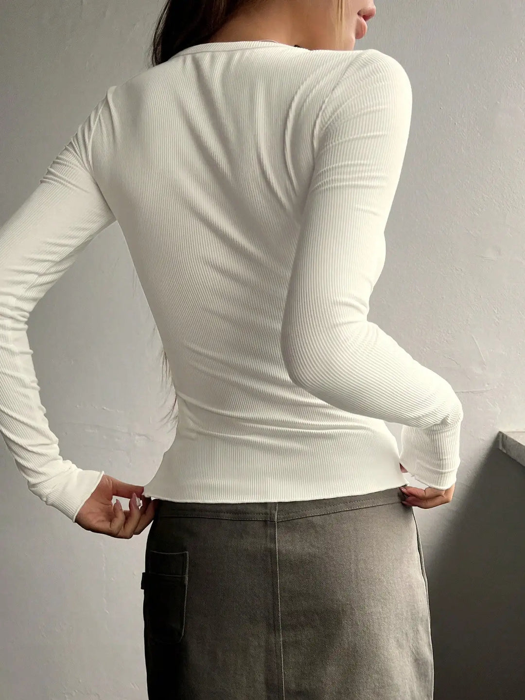 Dettaglio T-shirt Henley a coste donna con bottoni sul collo, texture morbida ed elegante.