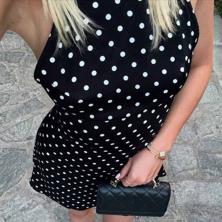 Mini abito donna a pois neri, con scollo all'americana. Eleganza retrò femminile per un'estate alla moda.