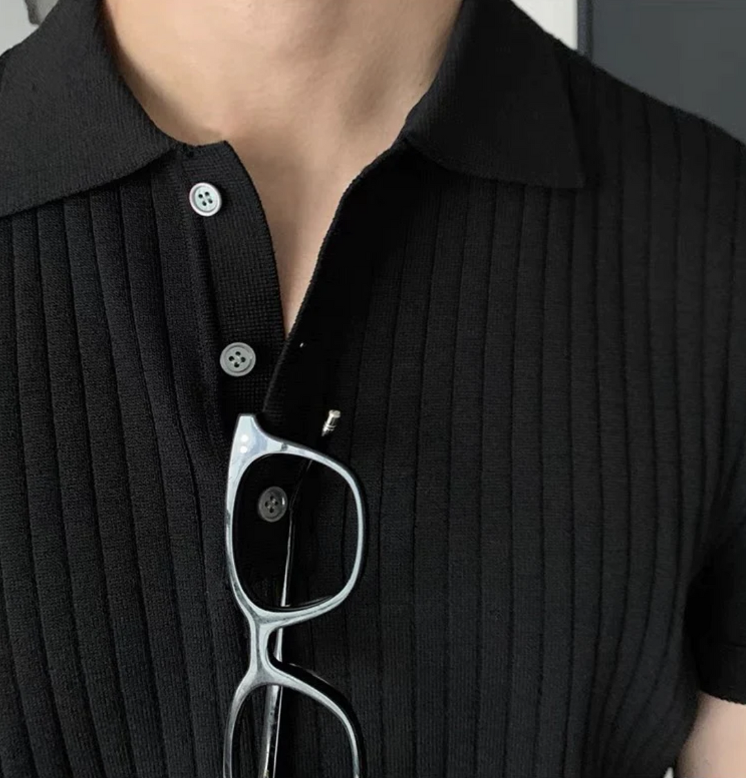 Abbigliamento uomo coordinato: polo nera in cotone e pantaloni rilassati. Un completo due pezzi moderno e versatile.