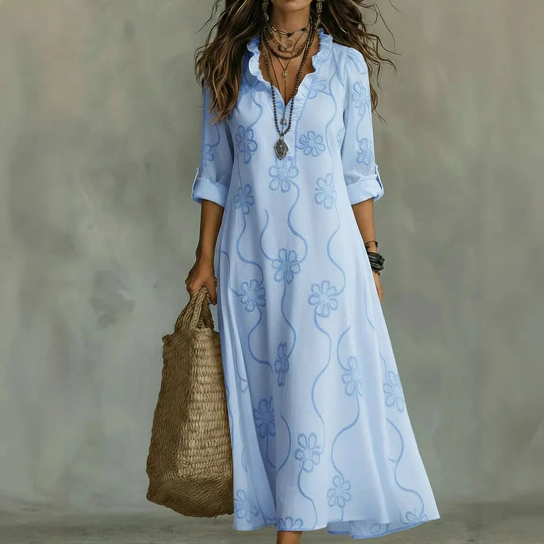 Primo piano del ricamo floreale su abito lungo boho donna. Dettaglio elegante dello scollo a V estivo.