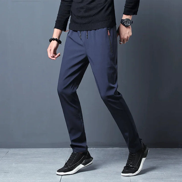 Pantaloni slim fit uomo casual con vita elastica e tasche zip, perfetti per tempo libero e viaggio.