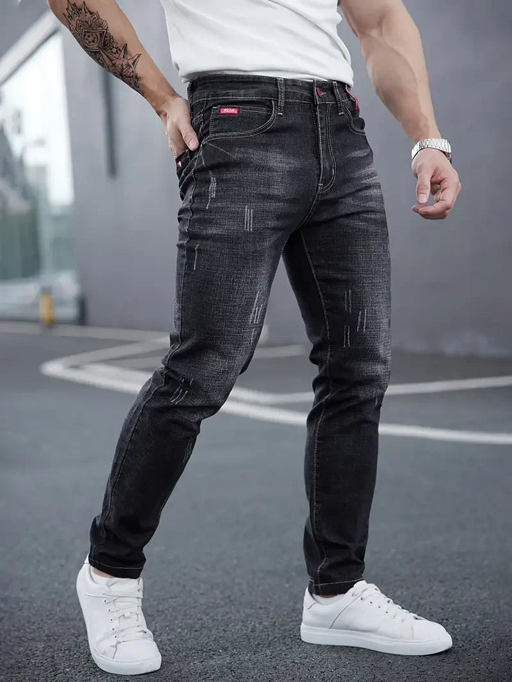 Jeans uomo tapered blu scuro, vita media, chiusura bottoni. Denim affusolato per stile casual.