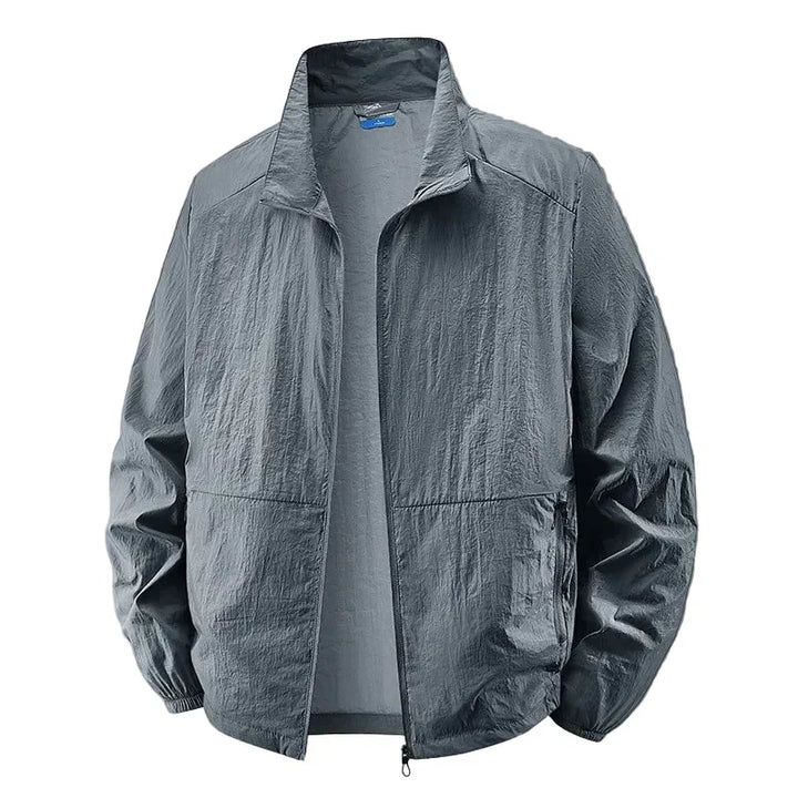 Uomo indossa giacca leggera multitasche grigia, look casual e moda maschile per lo stile urbano di tutti i giorni.